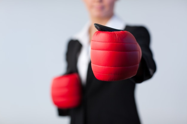 Photo femme d'affaires avec des gants de boxe sur