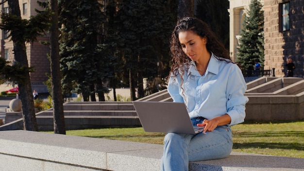 Femme d'affaires gestionnaire employeur travail en ligne étudiant avec ordinateur assis dans la ville à l'extérieur fille