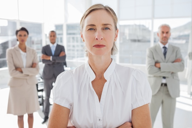 Femme d&#39;affaires grave debout avec les bras croisés