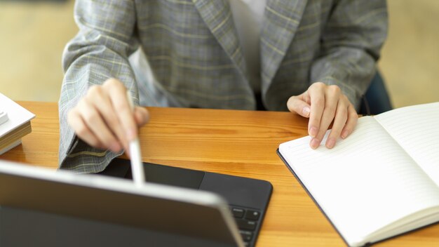 Femme d'affaires en gros plan travaillant sur une tablette portable à l'aide d'un stylet à l'écran