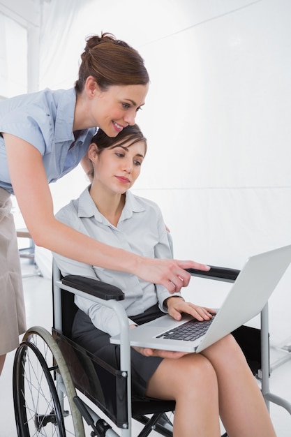 Femme d&#39;affaires handicapée en regardant portable avec collègue