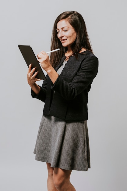 Femme d'affaires heureuse à l'aide d'une tablette numérique