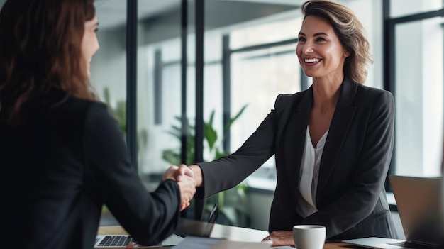Femme d'affaires heureuse gestionnaire poignée de main client pour un accord réussi à la table de réunion au bureau