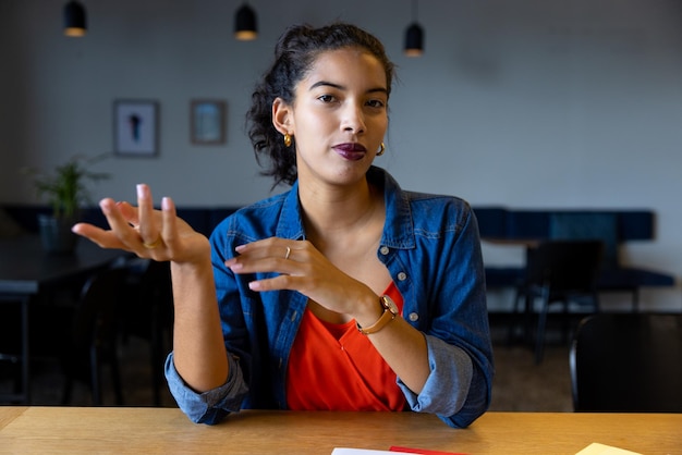 Une femme d'affaires heureuse et occasionnelle écoute pendant un appel vidéo au bureau.