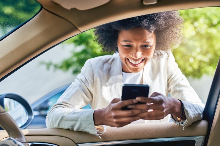 Photo femme d'affaires et heureuse à la porte de la voiture avec un téléphone pour la notification de messages texte et la vérification des courriels personne professionnelle et sourire sur le smartphone avec un chat mobile pour le trajet du matin ou la communication