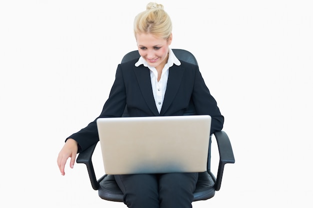 Femme d&#39;affaires heureux à l&#39;aide d&#39;ordinateur portable sur une chaise