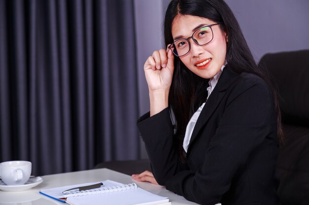 femme d&#39;affaires heureux assis au bureau