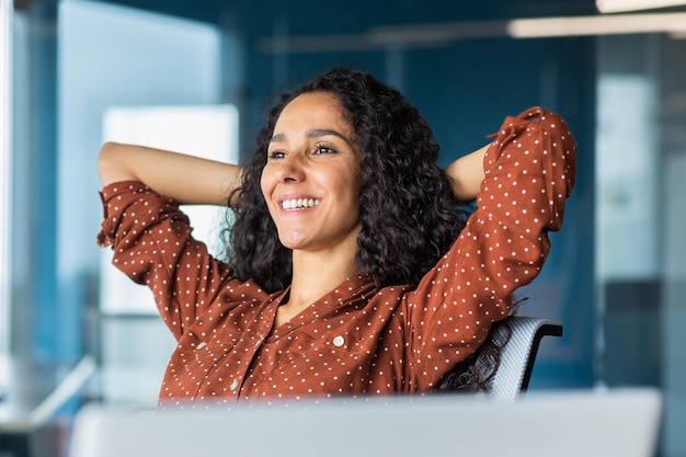 Une femme d'affaires hispanique heureuse et souriante a terminé son travail satisfait du résultat du travail et