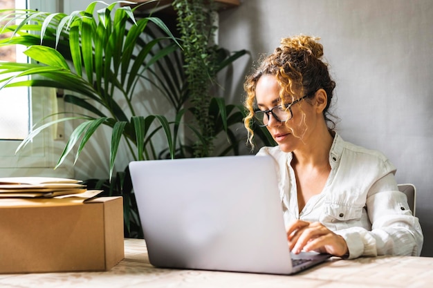 Photo femme d'affaires indépendante professionnelle travaillant au bureau à domicile avec un ordinateur portable et portant des lunettes
