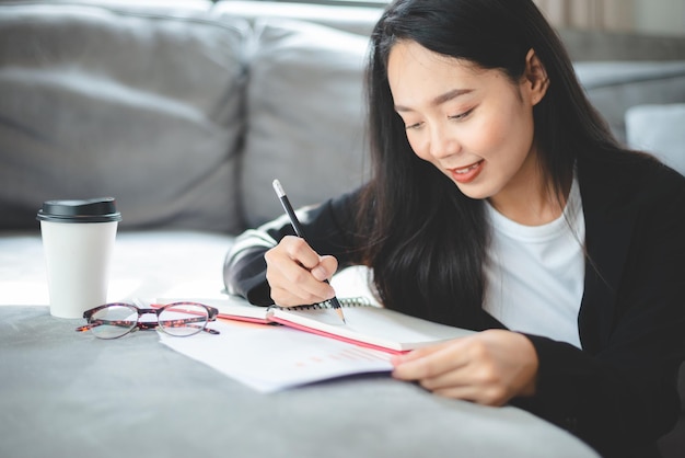 Femme d'affaires indépendante travaillant à domicile avec un ordinateur portable ou une tablette numérique