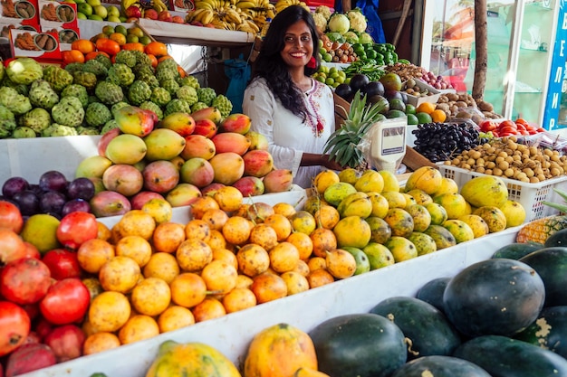 Une femme d'affaires indonésienne souriante au kerala goa vend une ferme de fruits et légumes