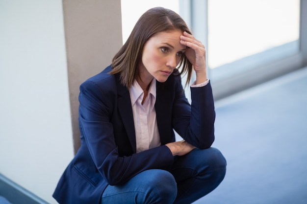 Femme d'affaires inquiet accroupi sur le sol