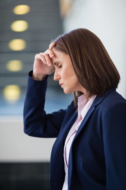 Femme d'affaires inquiet avec la main sur la tête