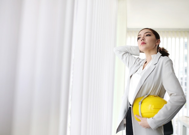 Photo femme d'affaires intelligente avec costume main tenir ingénieur casque permanent au bureau d'affaires