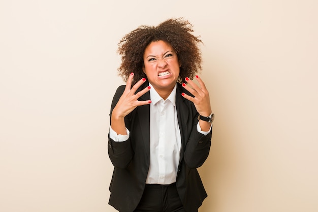 Femme d'affaires jeune bouleversé crier avec les mains tendues.