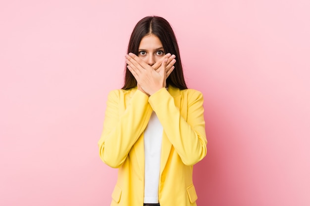 Femme d'affaires jeune choqué couvrant la bouche avec les mains.