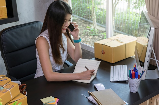 Femme d&#39;affaires jeune propriétaire d&#39;adolescent asiatique travail à la maison pour faire du shopping en ligne