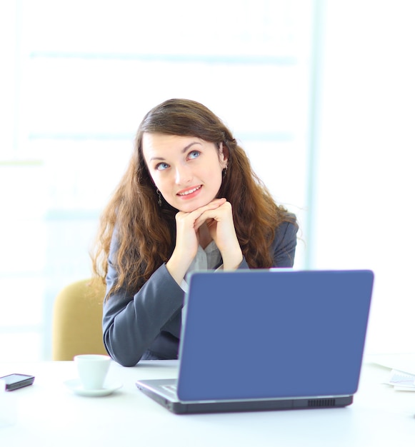 Femme d'affaires jeune rêveuse, travaillant avec l'ordinateur portable.