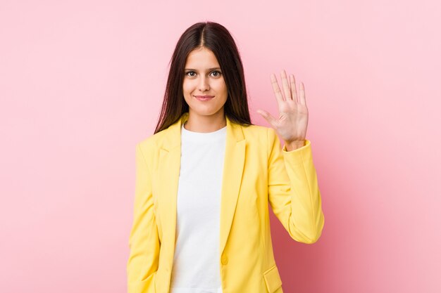 Femme d'affaires jeune souriant joyeux montrant le numéro cinq avec les doigts.