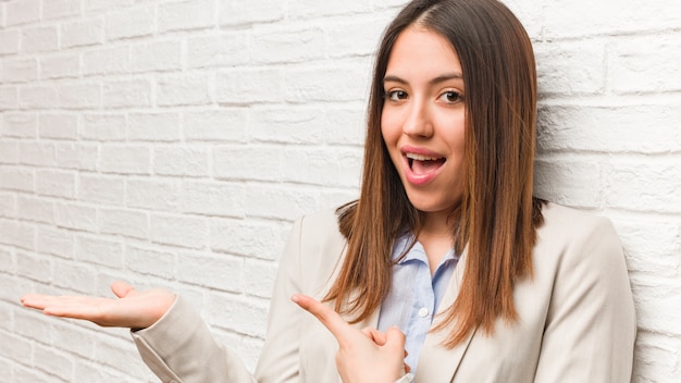 Femme d'affaires jeune tenant quelque chose avec la main