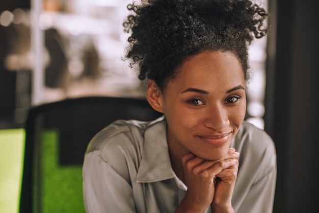 Femme d'affaires. Jolie jeune femme noire aux cheveux bouclés au bureau