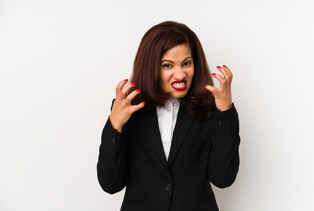 Femme d'affaires latine d'âge moyen isolée bouleversée crier avec les mains tendues.