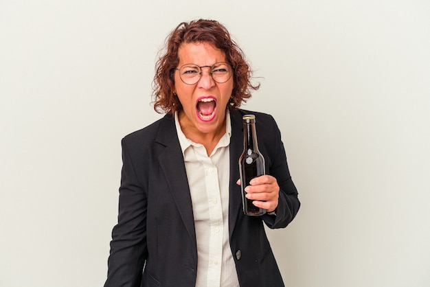 Femme d'affaires latine d'âge moyen tenant une bière isolée sur fond blanc criant très en colère et agressive.