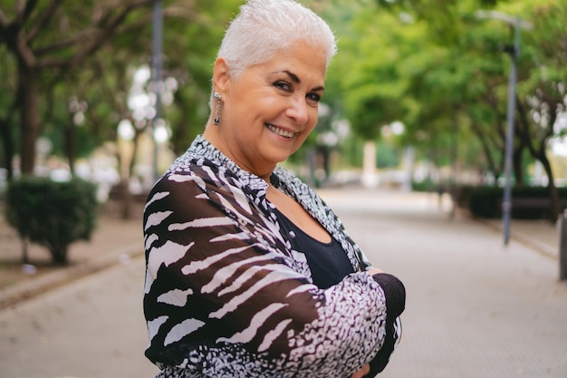 Photo une femme d'affaires latine plus âgée dans un parc semble confidente devant la caméra