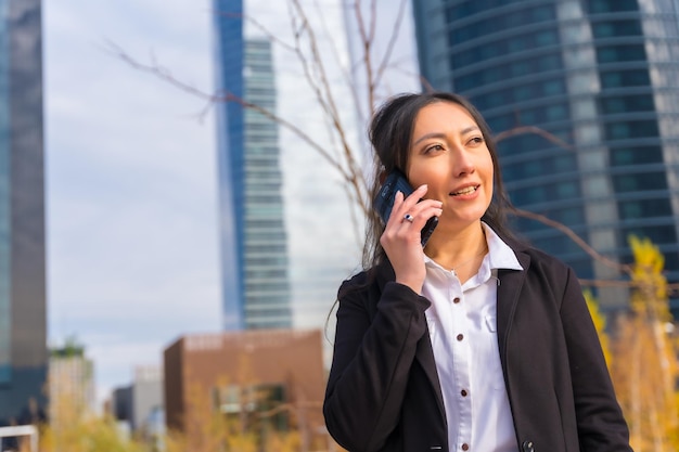 Femme d'affaires latine portrait d'entreprise parc d'affaires doux au téléphone