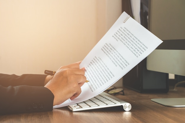 Femme d&#39;affaires lisant le document sur la table de travail