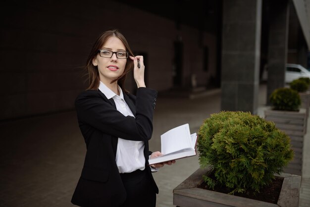 Une femme d'affaires avec des lunettes fait une note dans un concept de notebookManagement