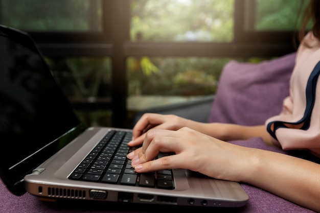 Femme affaires mains sur ordinateur portable au bureau