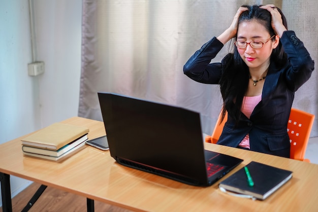 femme d&#39;affaires malheureuse a un problème sur son travail. Femme travaillant sur ordinateur portable et a essayé pour ha