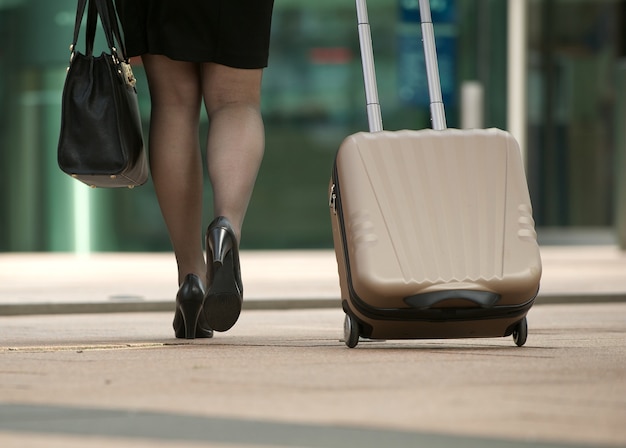 Photo femme d'affaires marchant avec sac et valise