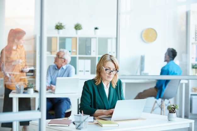 Femme d'affaires mature occupée avec du travail au bureau