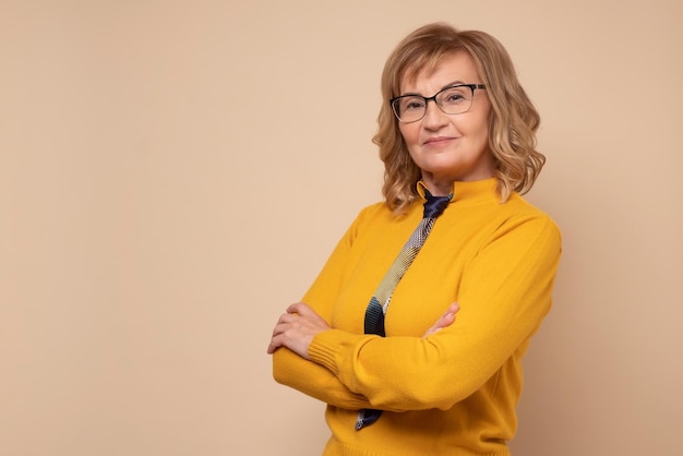 Femme d'affaires mature souriante dans des verres avec les mains jointes