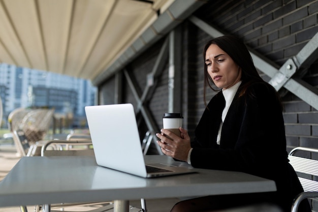 Femme d'affaires mature travaillant dans un café avec un ordinateur portable