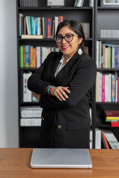 Photo une femme d'affaires mexicaine se tient debout avec les bras croisés et regarde la caméra en souriant.