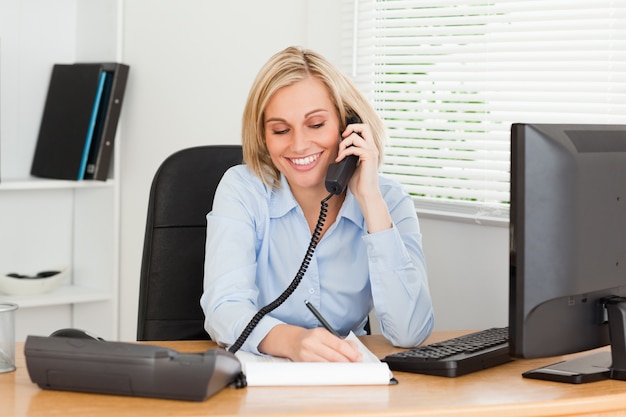 Femme d&#39;affaires mignon sur le téléphone écrit quelque chose