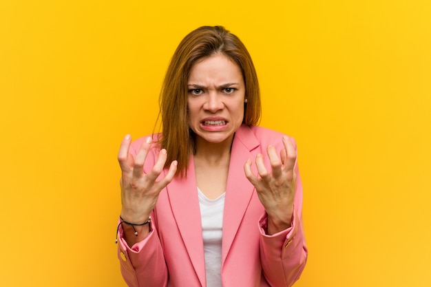 Femme d'affaires de mode jeune bouleversé crier avec les mains tendues.