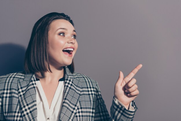 Femme d'affaires à la mode portant un blazer à carreaux posant à l'intérieur