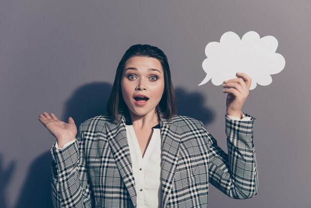 Femme d'affaires à la mode portant un blazer à carreaux posant à l'intérieur