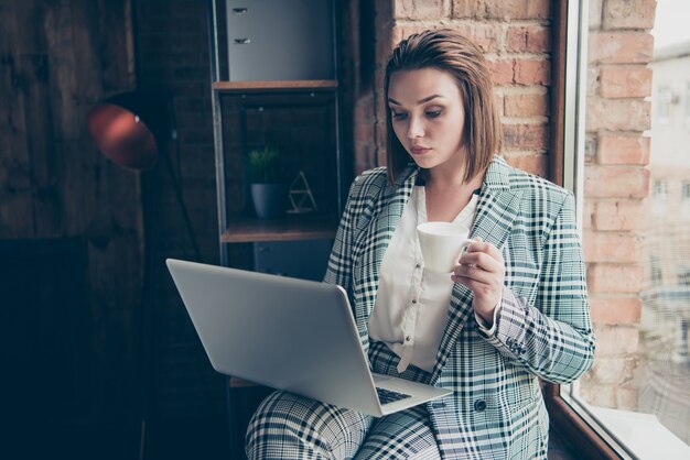 Femme d'affaires à la mode posant à l'intérieur