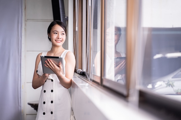 Femme d&#39;affaires moderne stainding avec tablette au bureau, espace copie.