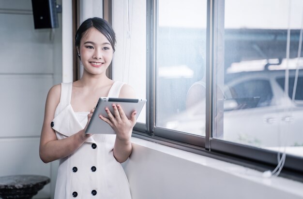 Femme d&#39;affaires moderne stainding avec tablette au bureau, espace copie.