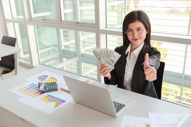 Femme D'affaires Montrant Le Rapport De Synthèse De L'entreprise Et Graphique Avec De L'argent Sur Les Mains