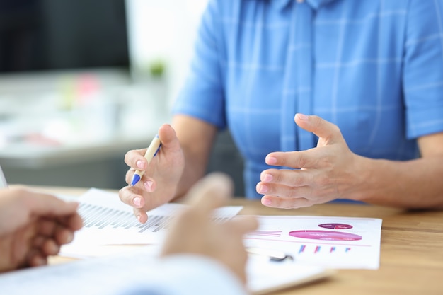 Une femme d'affaires montre un bon rapport statistique expliquant les avantages des conseils du gestionnaire d'affaires