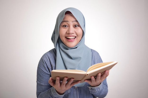 Femme d'affaires musulmane lisant un livre surpris