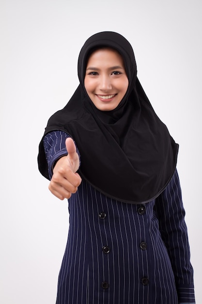 Femme d'affaires musulmane réussie souriante et confiante, abandonnant le pouce vers le haut ; approuvant le pouce vers le haut portrait d'une femme d'affaires islamique ; femme d'affaires, femme d'affaires donnant acceptant le geste du pouce vers le haut