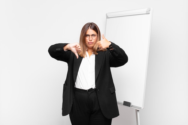 Femme d'affaires négative devant un tableau blanc